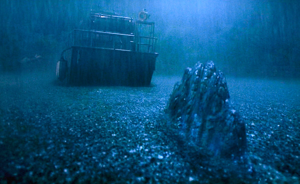 La vela delata la presencia de un espinosaurio nadando en un río en Parque Jurásico III